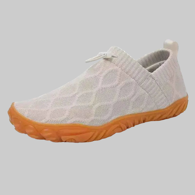 Beige slip-on shoe with orange sole on a white background