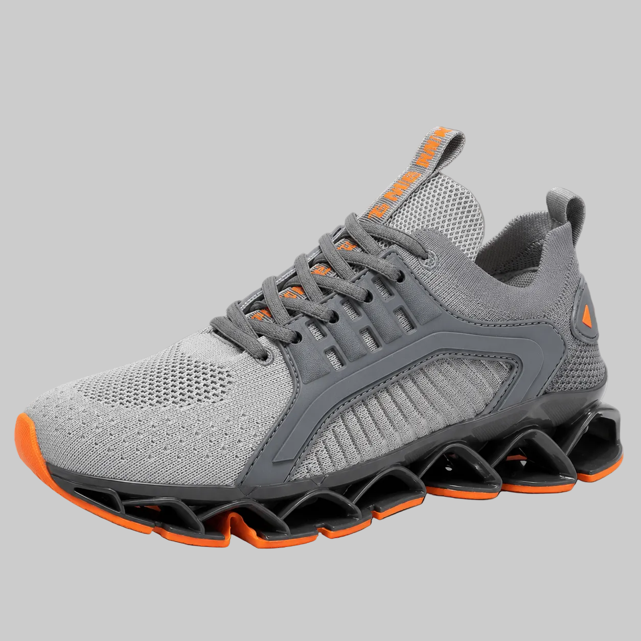 A gray knit athletic sneaker with a unique wavy black and orange sole, gray laces, and orange accents on the tongue and heel, shown against a solid gray background.