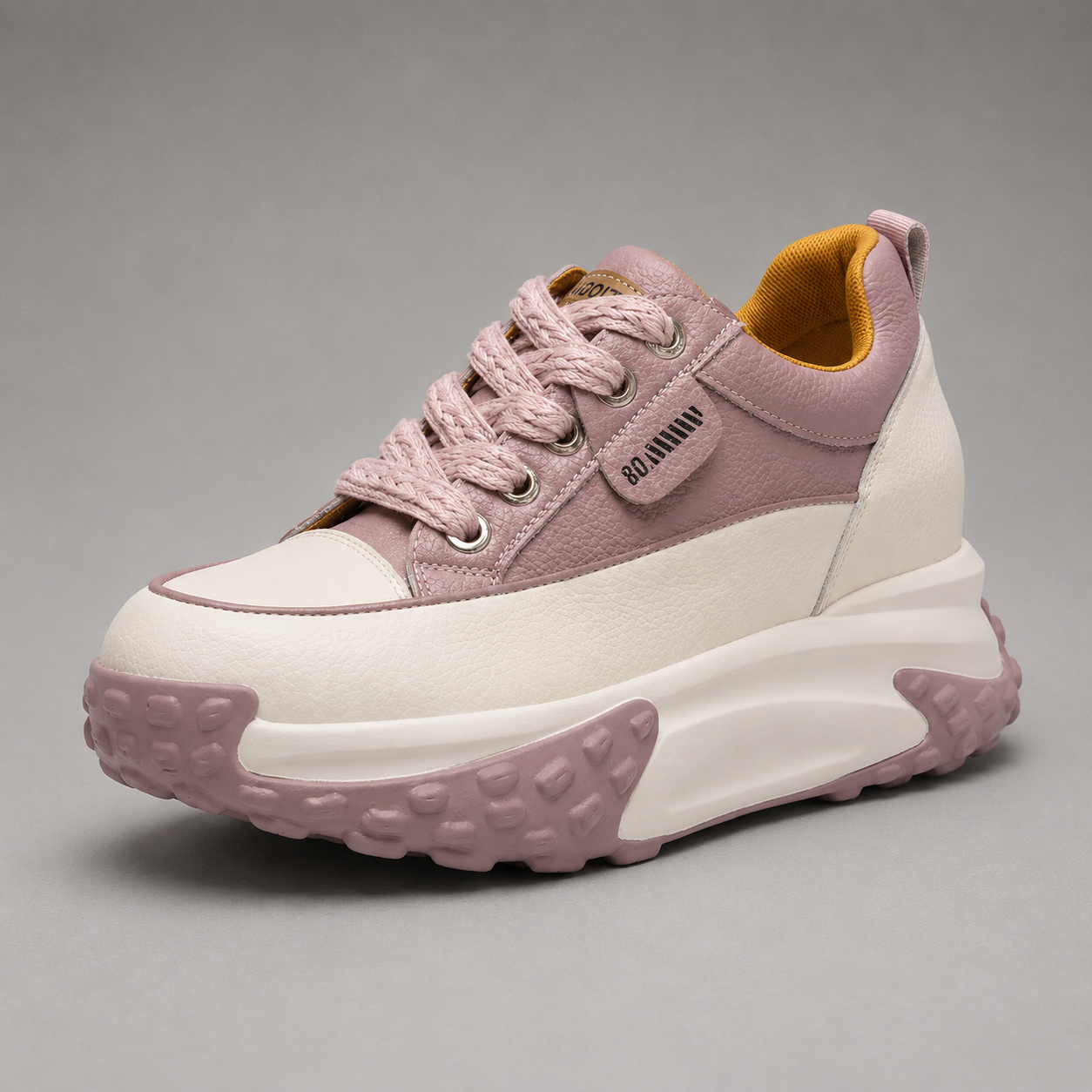 Pink and white sneaker with a thick sole on a gray background