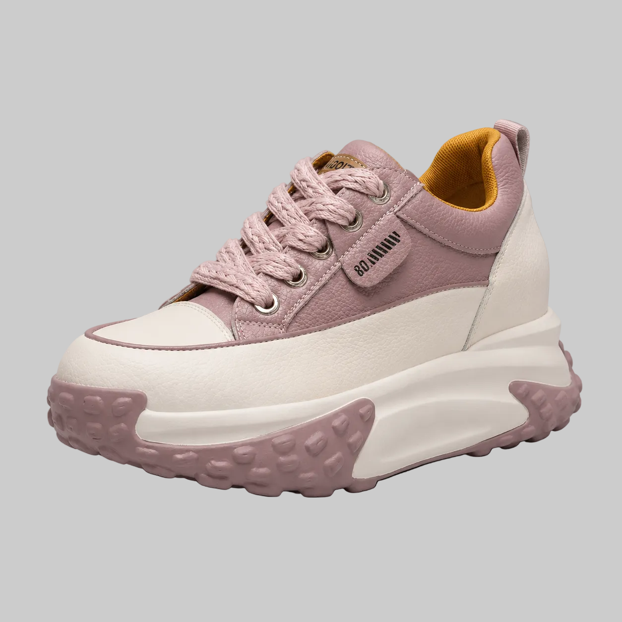 Pink and white sneaker with a thick sole on a gray background