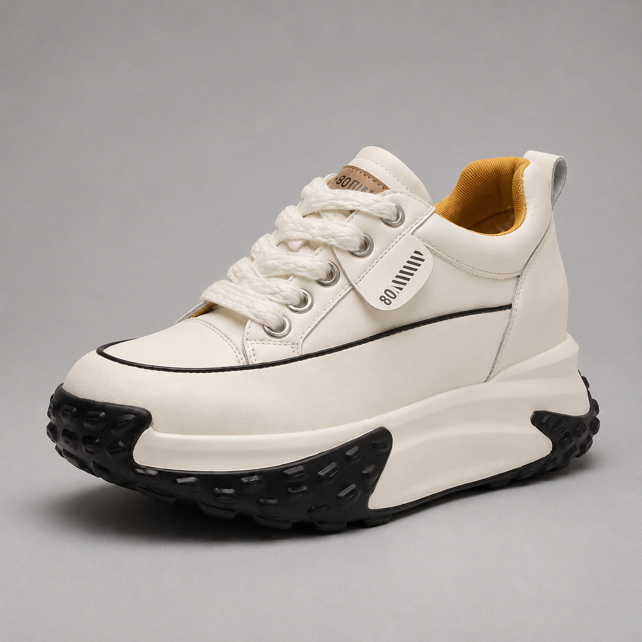 White sneaker with black sole on a gray background