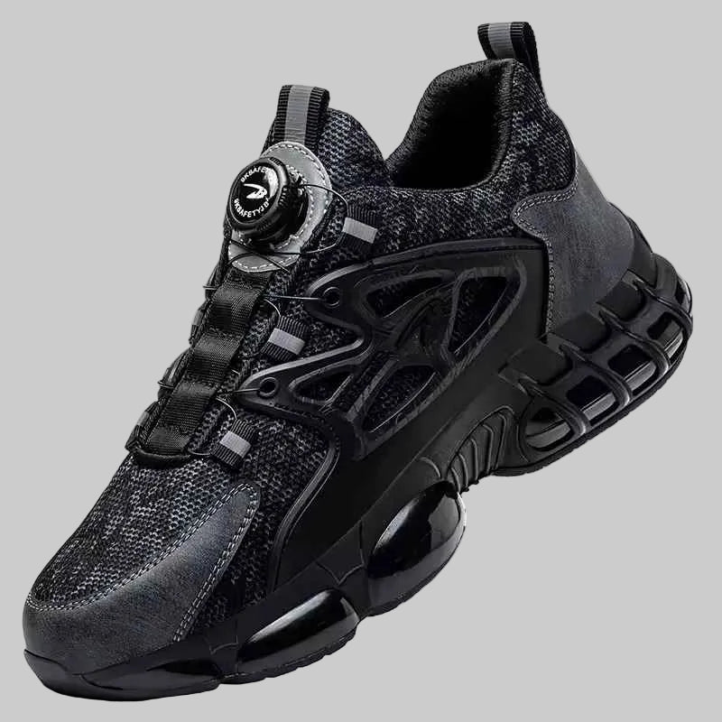 A black and dark gray athletic sneaker with a circular dial closure system on the side, shown against a solid gray background.