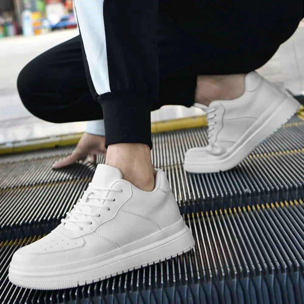 White sneakers worn on a person's feet, sitting on a metal surface.