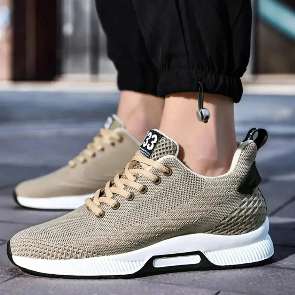 Beige sneakers worn with black pants on a blurred outdoor background