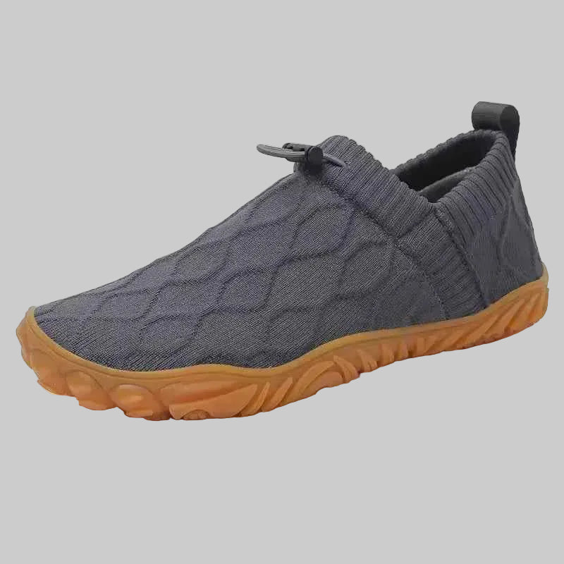 Gray slip-on shoe with a brown sole on a white background